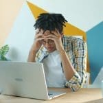 adult looking overwhelmed at desk trying to focus with ADHD